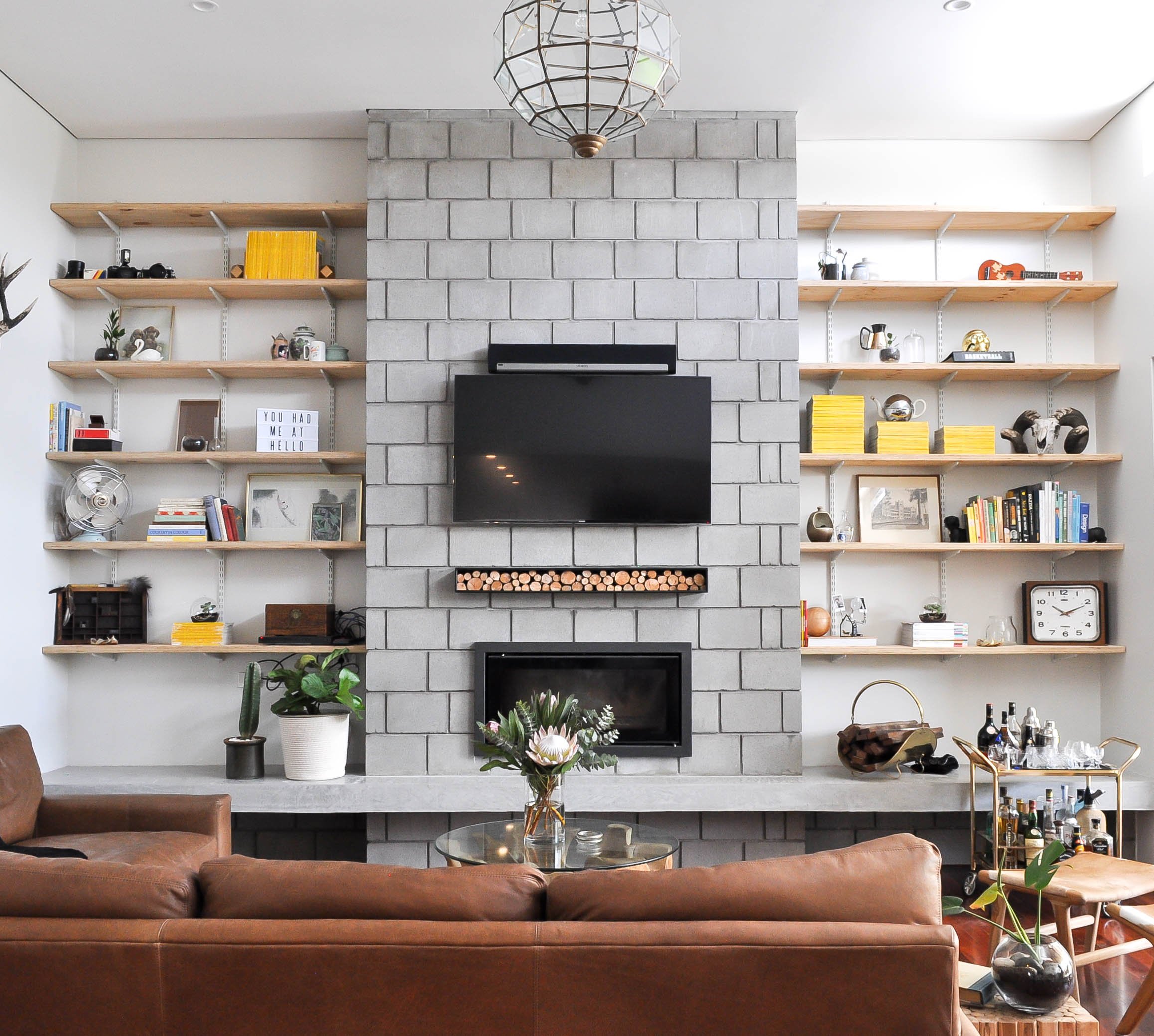 living room with open shelves and wall mount fireplace